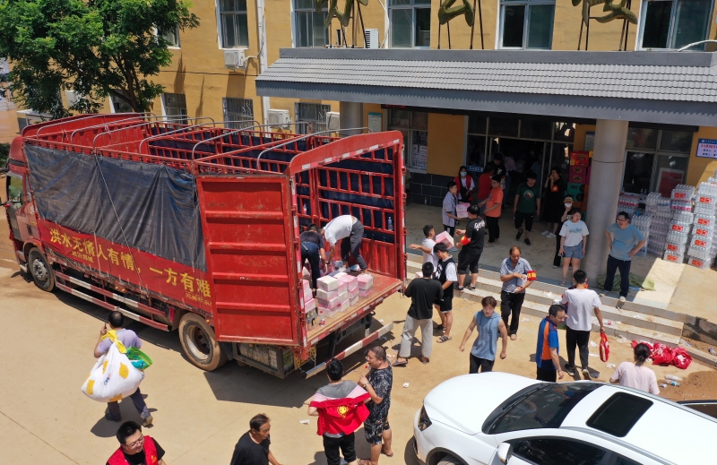 7月24日，志愿者在淇县职业中等专业学校安置点搬运物资（无人机照片）。

