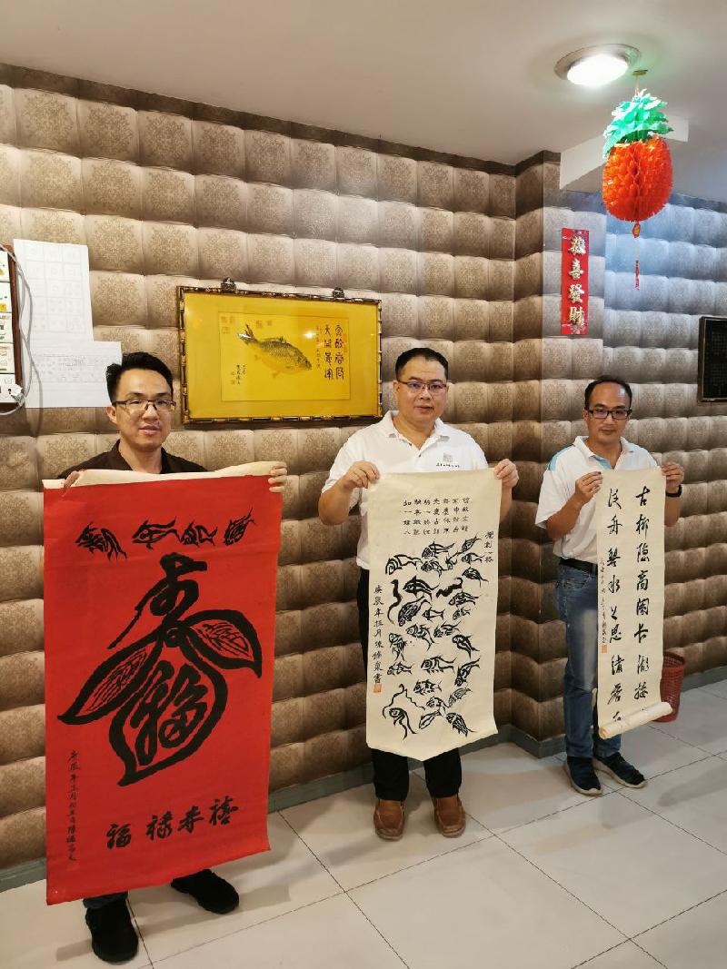 左起为陈礼忠，笔者薛君毅，陈礼扬一起展示陈锡泉书法。