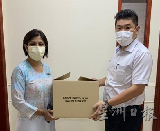 朱建华（右）移交唾液冠病检测试剂盒给卫生县属代表。