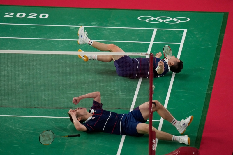 谢定峰（左）与苏伟译拿下铜牌战胜利后，激动得躺在场上欢庆。（美联社照片）