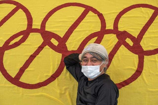 Artist Takatoshi Sakuragawa poses with his anti-Olympic banner. AFP