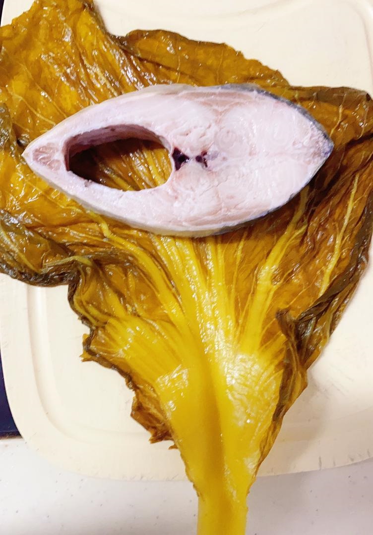 切片的刺壳鱼必须先用酸菜包裹起来，鱼肉在炖煮的时候才不会散开。