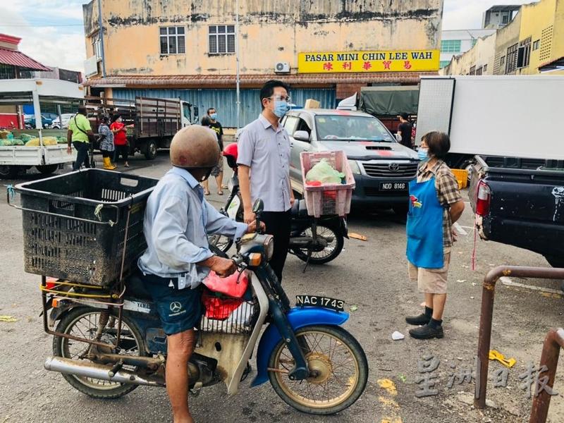 张聒翔（中）于4日清早到马口公市了解贩商收拾环境的情况，并与他们交流。
