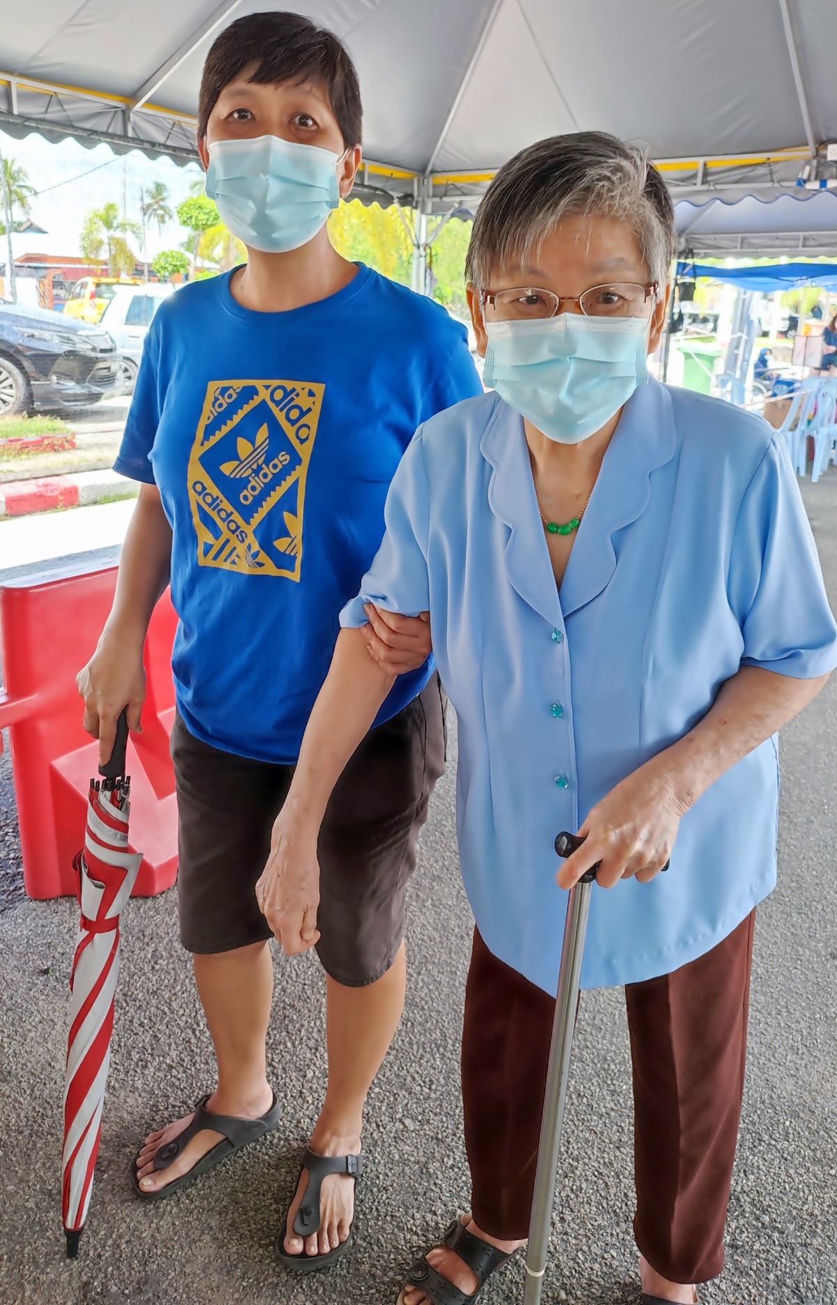 85岁陈老太(右)柱著杖，在女儿陪同下，登门接种疫苗。