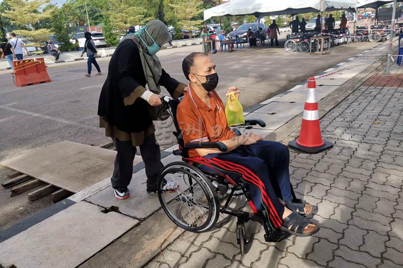 一名坐轮椅的乐龄人士刚接种疫苗，准备回家。