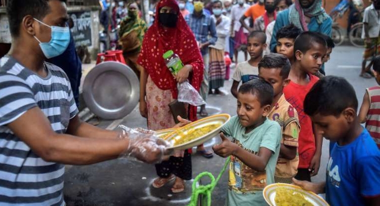 A volunteer from Mehmankhana distributes food for pandemic-affected people in the Lalmatia area of Dhaka. AFP A volunteer from Mehmankhana distributes food for pandemic-affected people in the Lalmatia area of Dhaka. AFP