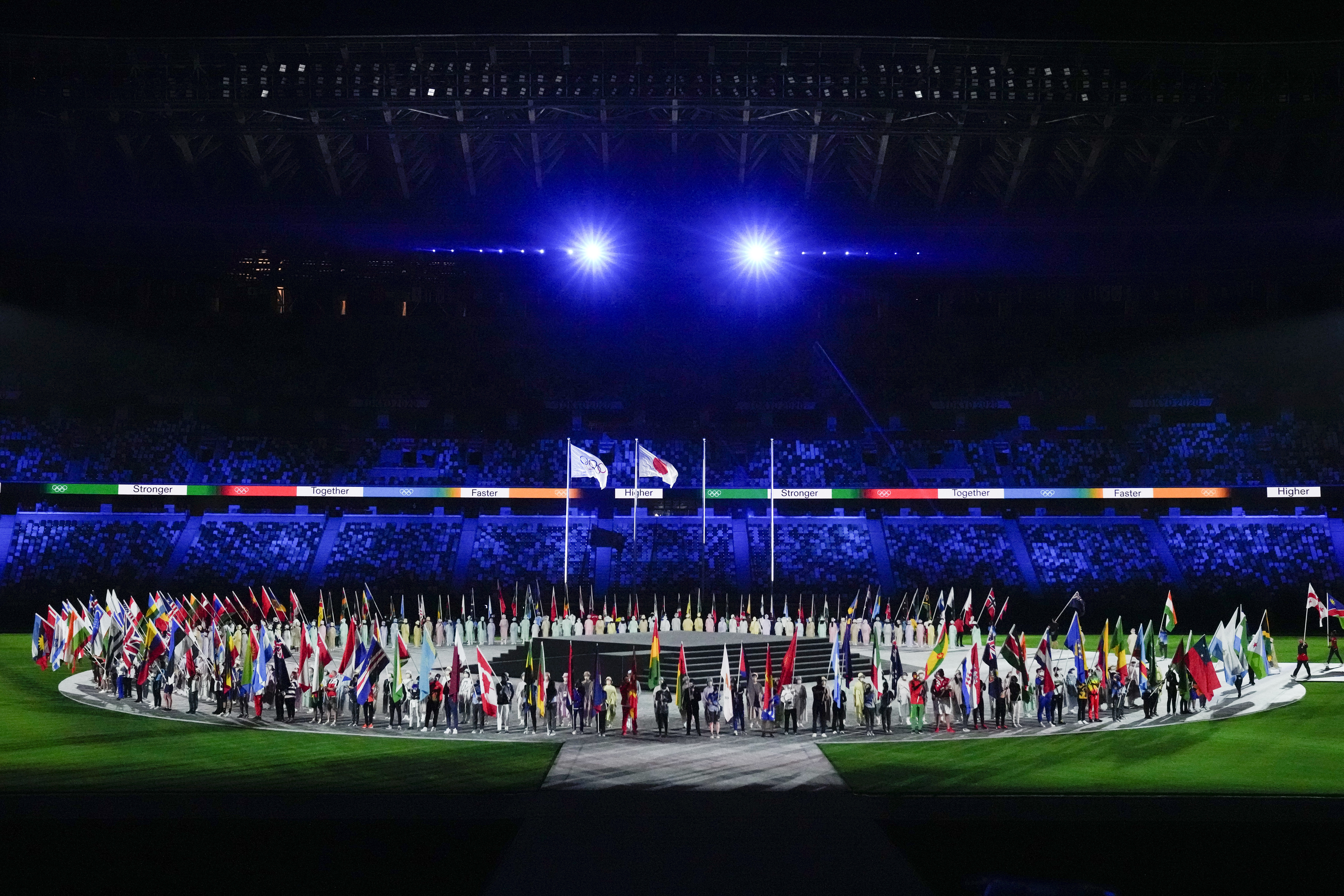 3周转眼过去，东京奥运在冠病疫情下圆满结束，图为闭幕式上的各代表团旗帜。（美联社照片）

