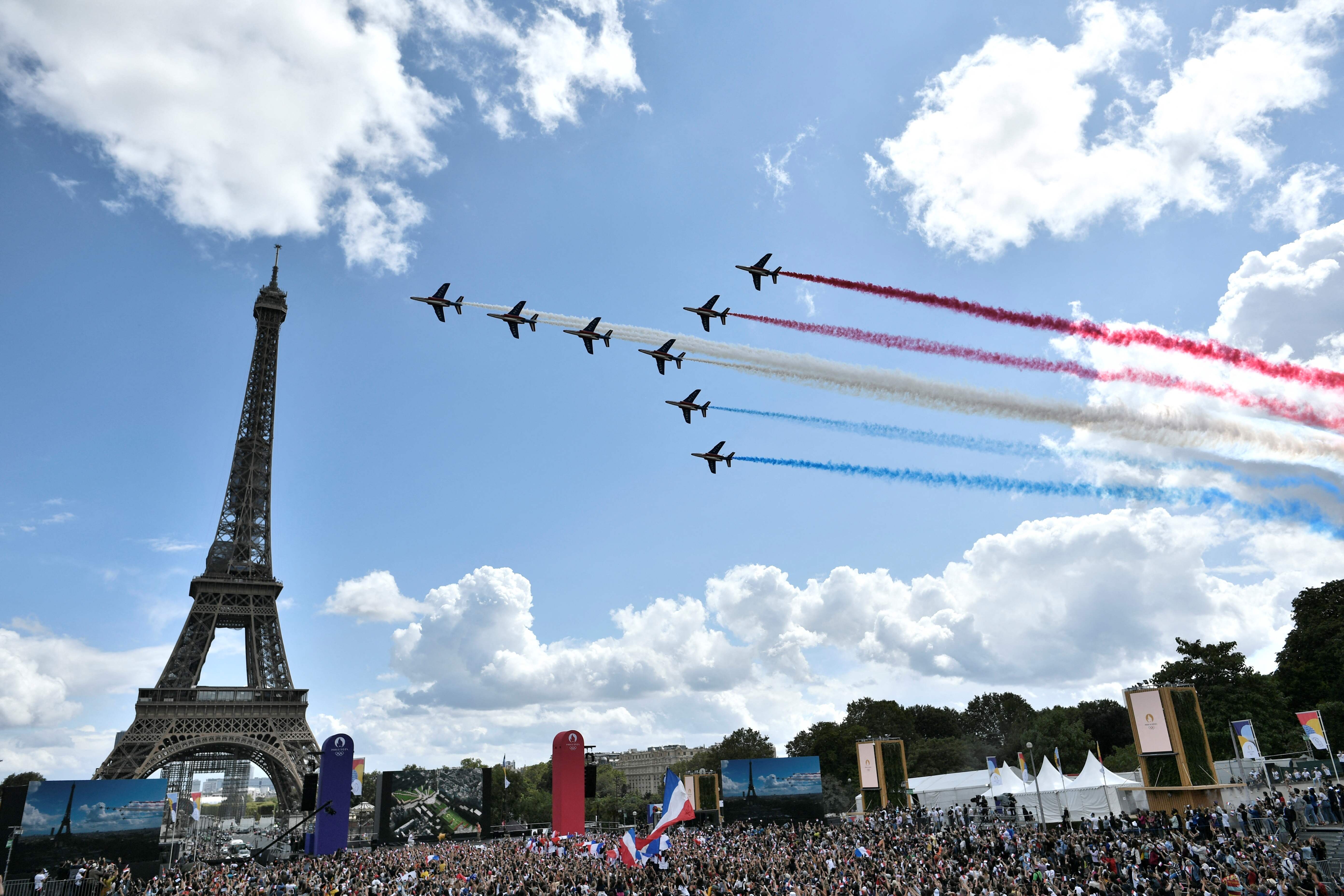 东京奥运闭幕仪式期间，巴黎也同步为2024年举办奥运会而造势，只见喷射着法国国旗颜色烟雾的“法兰西巡逻兵”飞行表演队在埃菲尔铁塔前飞过。（法新社照片）

