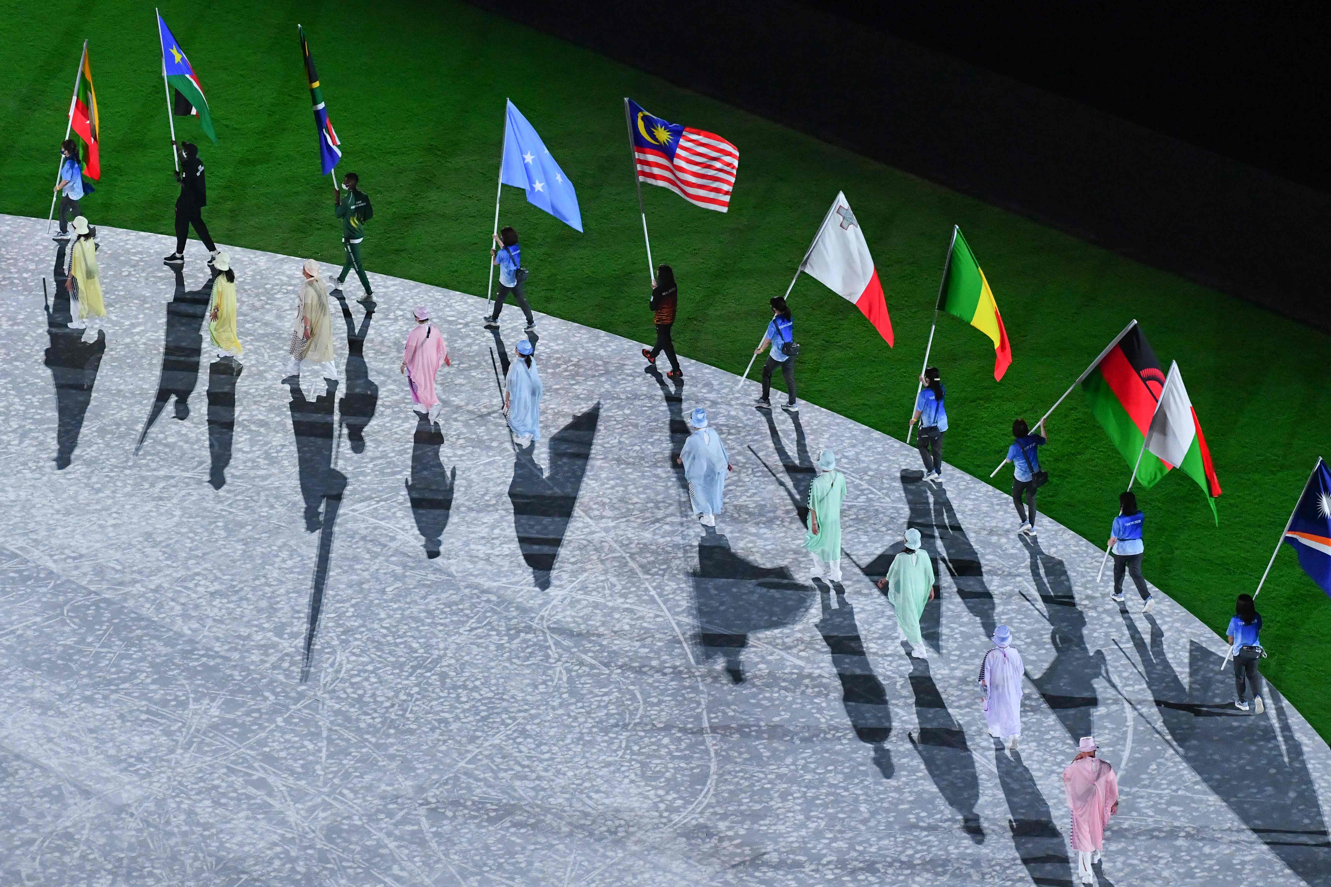 闭幕式上，运动员携各自国旗亮相，挥舞马来西亚辉煌条纹的是跳水名将潘德莉拉。（法新社照片）


