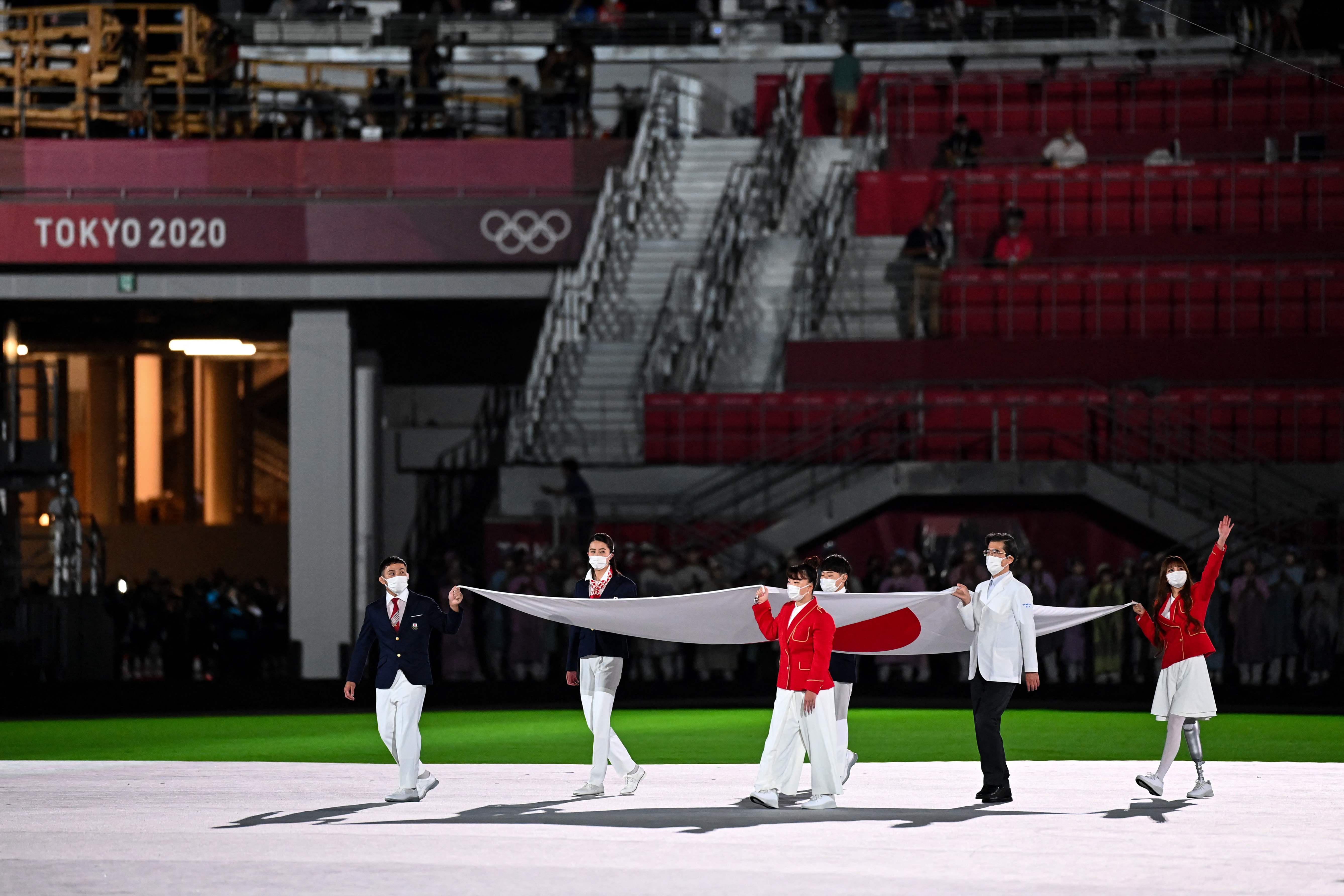 东京奥运闭幕式与开幕式一样，禁止观众入场，图为闭幕式开始时奥运会旗与日本国旗（图）进场。（法新社照片）

