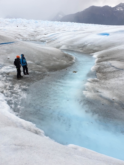 浅蓝色的小川，和白色的冰川，构成一幅美丽的画面。穿蓝色外套的是我们的徒步向导。

