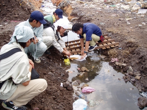 与福冈大学研究生正在进行土埋场的废水研究。