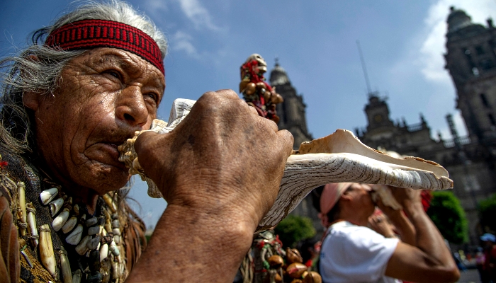 An indigenous man blows an atecocolli -pre-Hispanic instrument during the celebration of the 500th anniversary of the last day of indigenous domain ahead of the fall of Tenochtitlan to the Spanish at the Zocalo Square in Mexico City. AFP