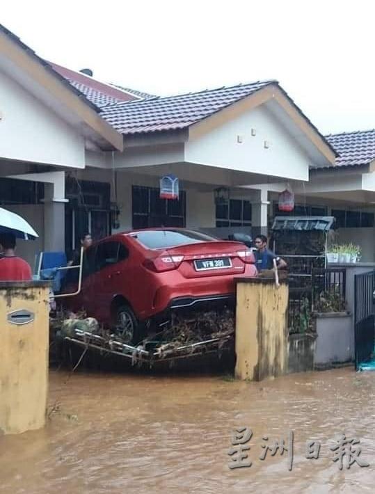  汽车被洪水冲进住家庭院，突显大自然的山洪威力。