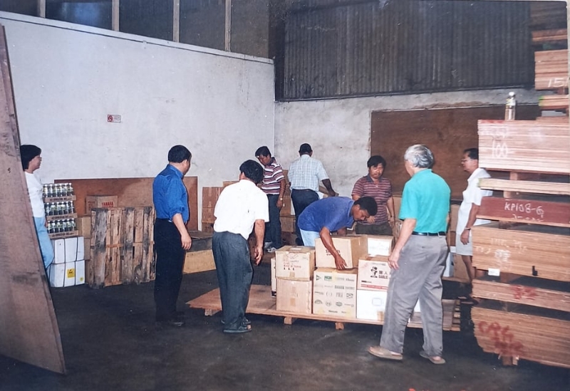 书香楼的藏书，从新加坡运进来后先置放在工厂的货仓内；图中为书香楼负责人在整理一包包送抵书籍的场面。