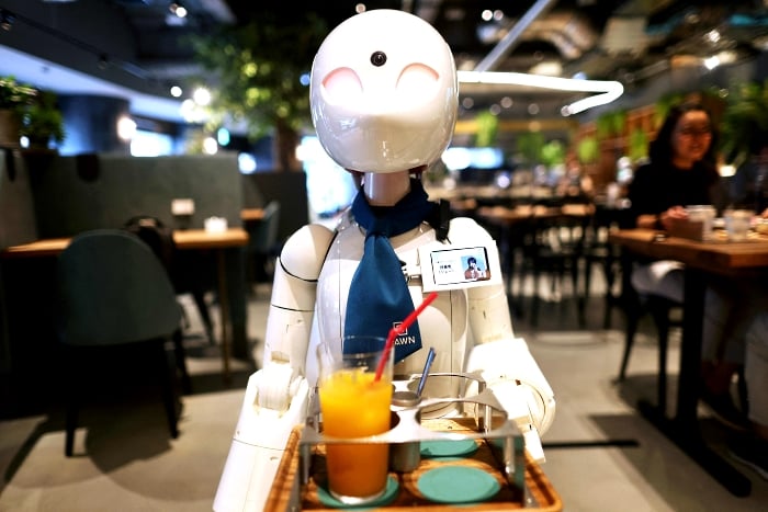 A humanoid robot delivers drinks to customers at the Dawn Cafe in Tokyo. AFP