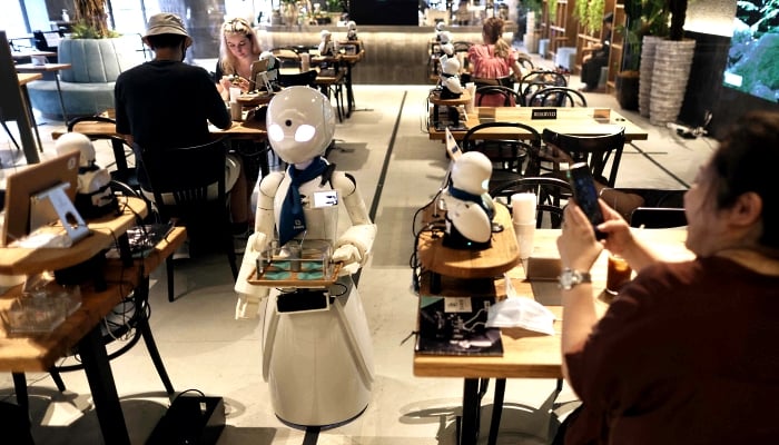 A humanoid robot delivers drinks to customers at the Dawn Cafe in Tokyo. AFP