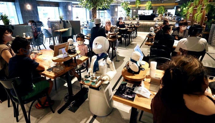 A humanoid robot delivers drinks to customers at the Dawn Cafe in Tokyo. AFP