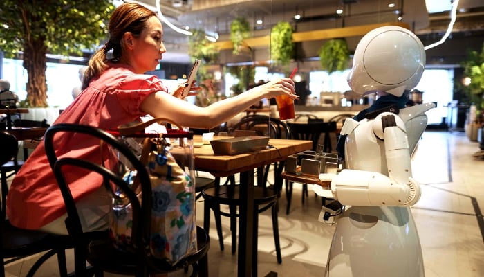 A humanoid robot delivers drinks to customers at the Dawn Cafe in Tokyo. AFP