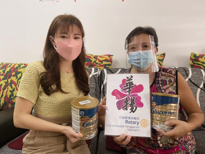 洪炘璇（左）代表石城华扬扶轮社，分派营养奶粉给该社2年前开始援助的首位癌友陈妙芝。