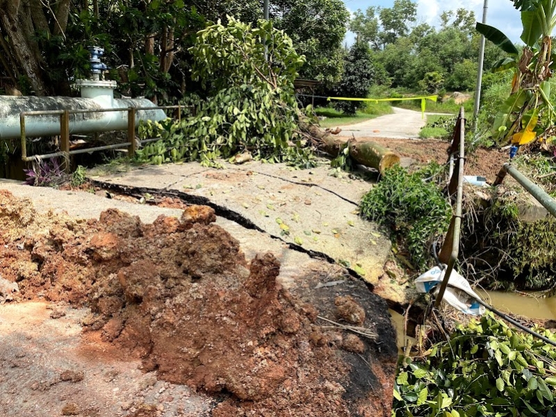 受豪雨侵袭，丹绒拉务路Petron油站后方一条道路坍塌。
