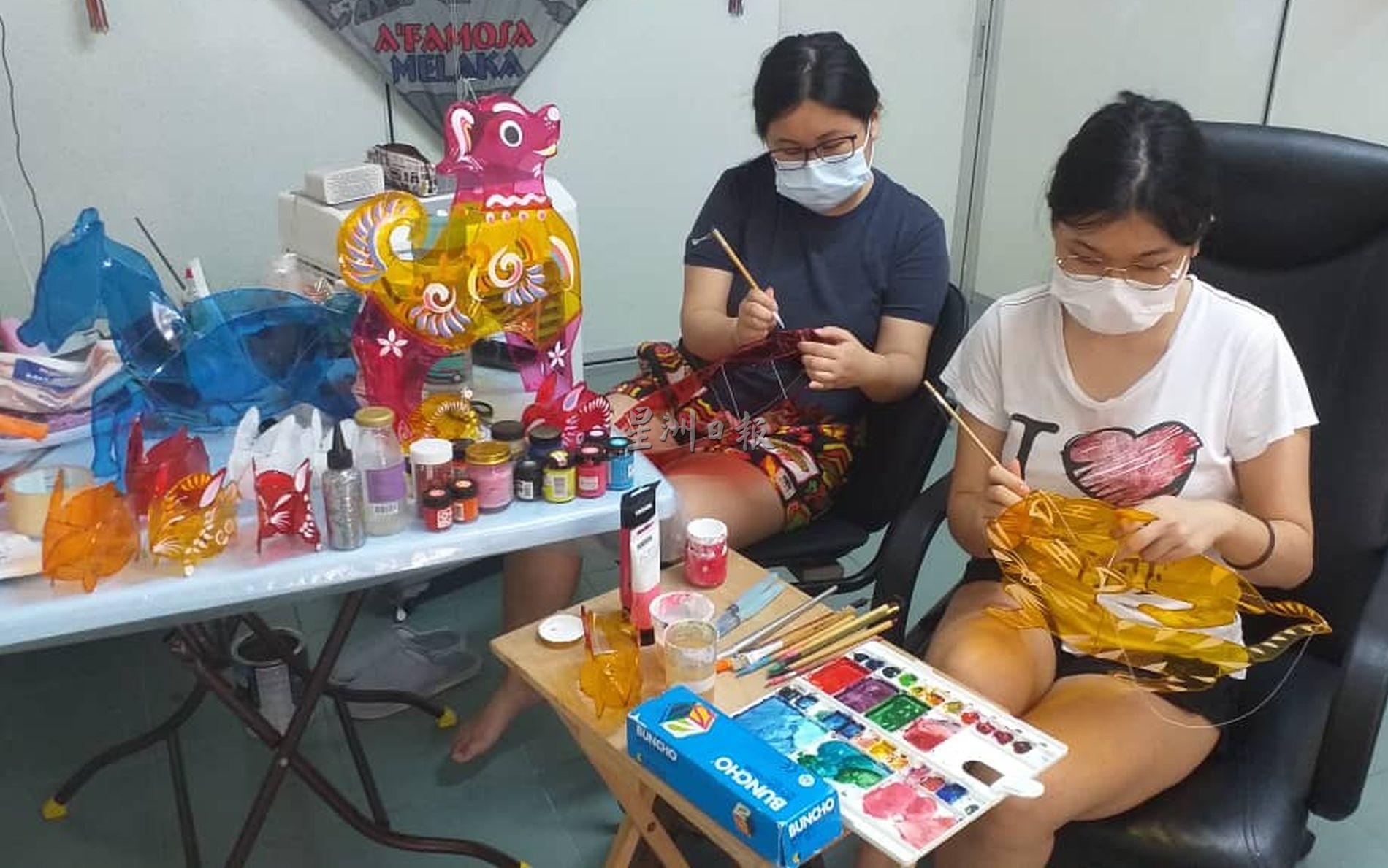 张瑞清的女儿们协助彩绘玻璃纸灯笼。