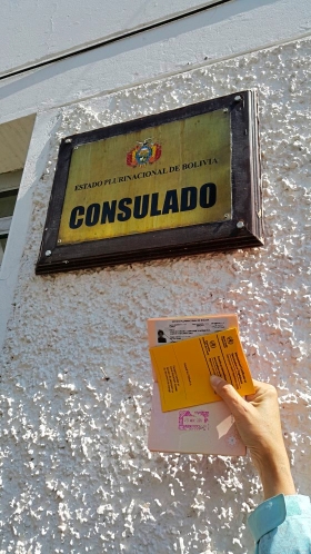 在库斯科玻利维亚大使馆外手持玻利维亚签证和疫苗注射证明书。

